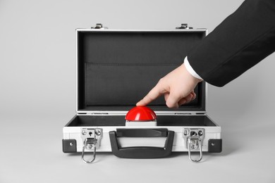 Photo of Man pressing red button of nuclear weapon on light gray background, closeup. War concept