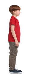 Photo of Little boy in red polo shirt and beige pants on white background