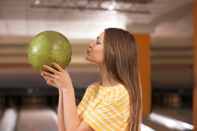 Photo of Young woman with ball in bowling club