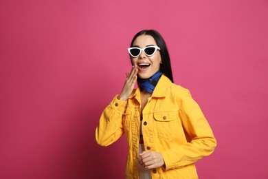 Photo of Fashionable young woman in stylish outfit with bandana on pink background, space for text