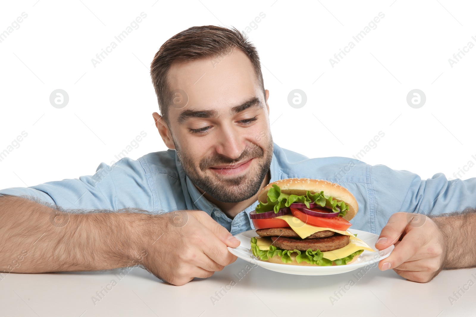 Photo of Young hungry man with tasty burger on white background