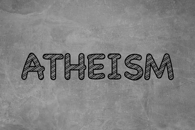 Image of Word Atheism on grey stone surface. Philosophical or religious position