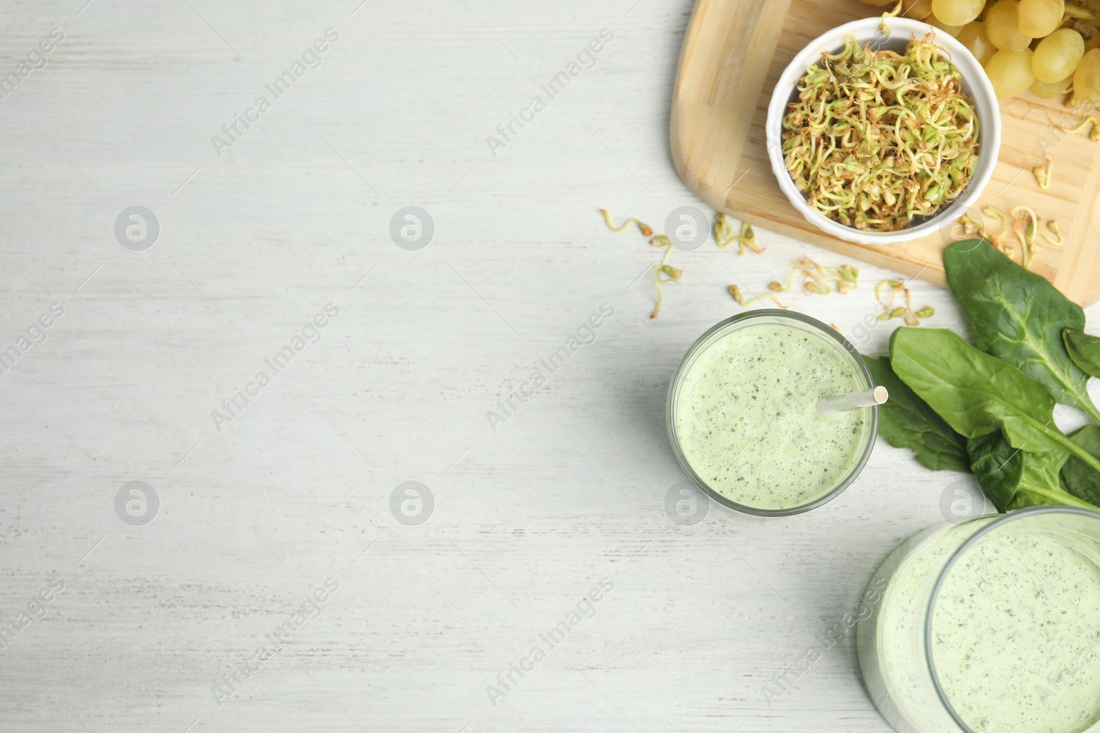 Photo of Flat lay composition with green buckwheat smoothie on white wooden table, space for text