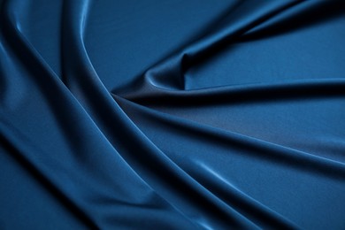 Image of Crumpled dark blue silk fabric as background, closeup