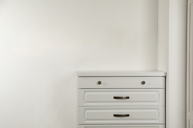 Modern chest of drawers near white wall