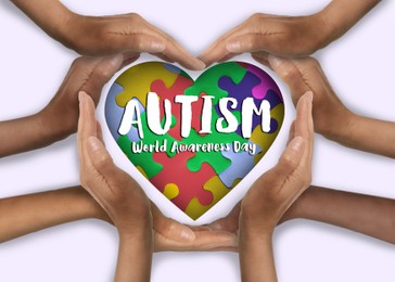 Image of World Autism Awareness Day. People forming heart with their hands on white background, top view
