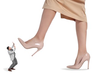 Image of Big woman stepping onto small man on white background