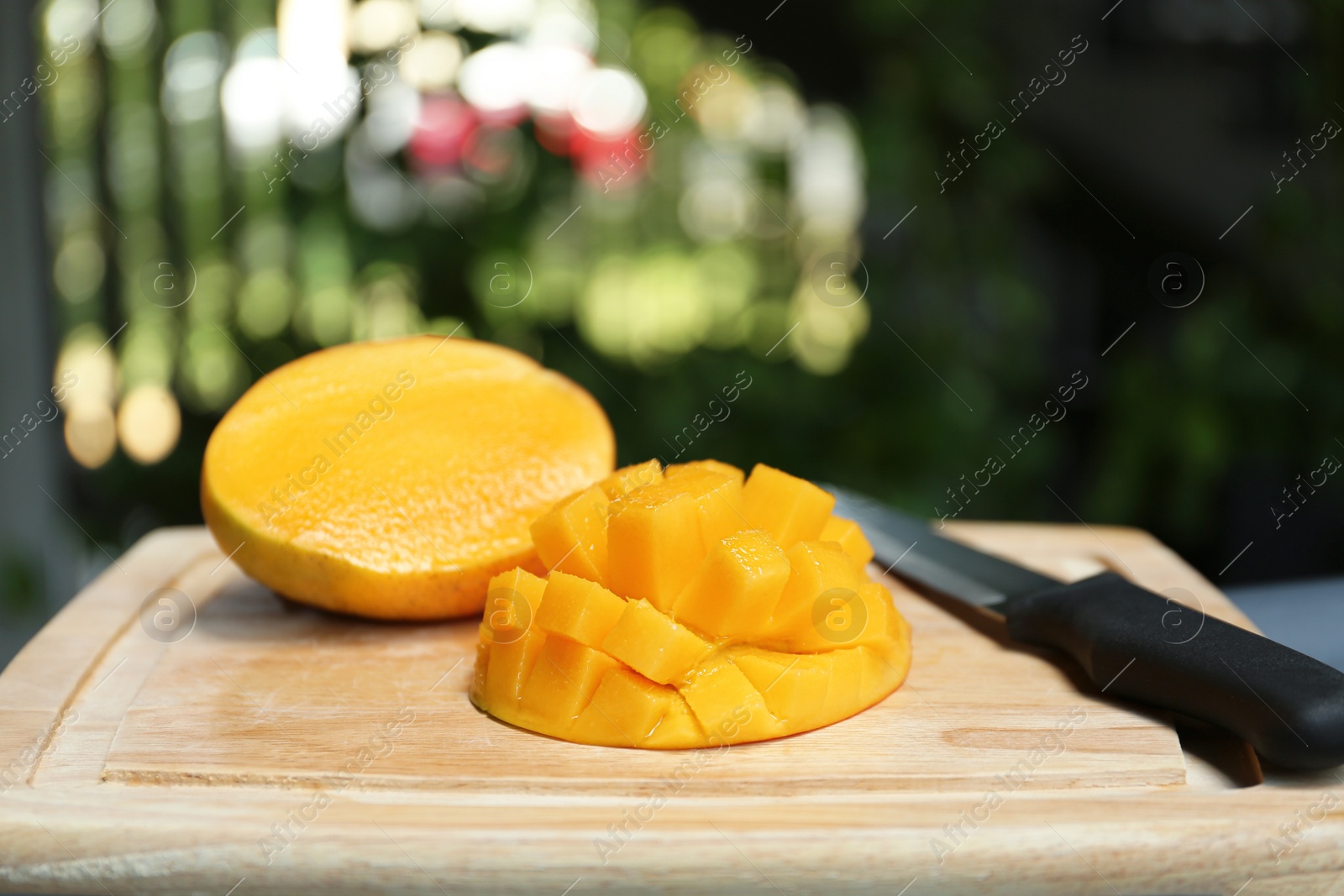 Photo of Cut ripe juicy mango on wooden board