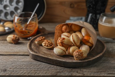 Photo of Freshly baked homemade walnut shaped cookies on wooden table, closeup. Space for text