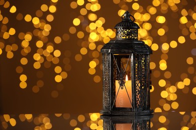 Photo of Arabic lantern on mirror surface against blurred lights, space for text