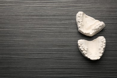 Dental model with gums and space for text on grey wooden table, top view. Cast of teeth