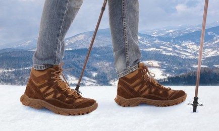 Image of Man with trekking poles in snowy mountains, closeup