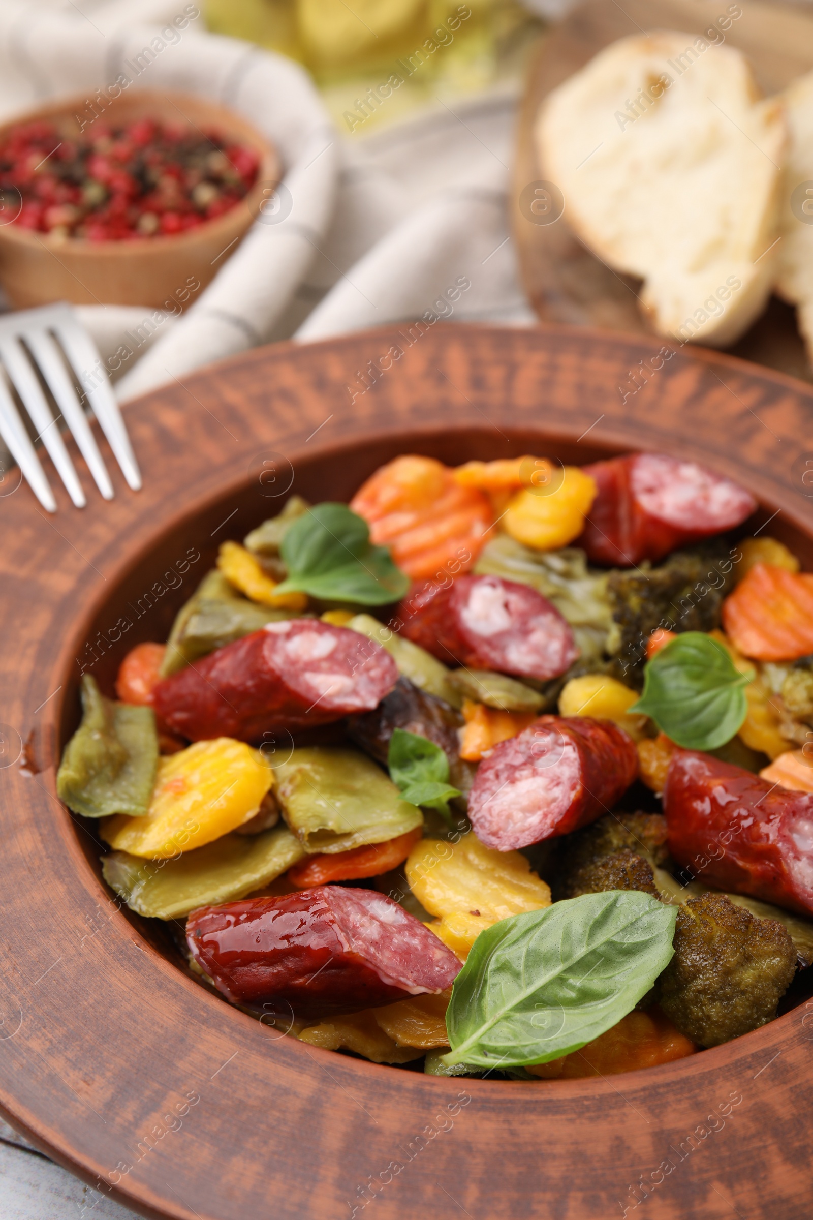 Photo of Delicious sausage and baked vegetables on table, closeup