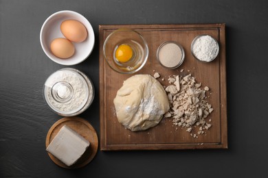 Photo of Different types of yeast, eggs, flour and dough on grey wooden table, flat lay