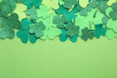 St. Patrick's day. Decorative clover leaves on green background, top view. Space for text