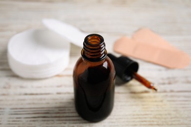 Photo of Bottle of medical iodine on white wooden table, closeup