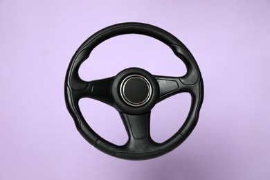 Photo of New black steering wheel on violet background