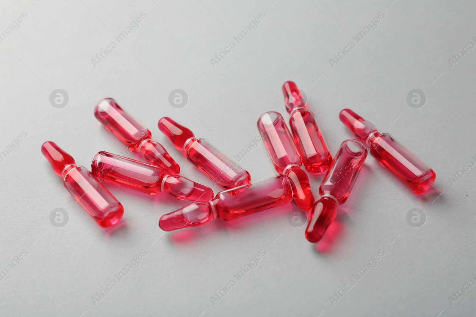 Photo of Glass ampoules with liquid on white background