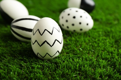 Photo of Traditional painted Easter eggs on green lawn, space for text