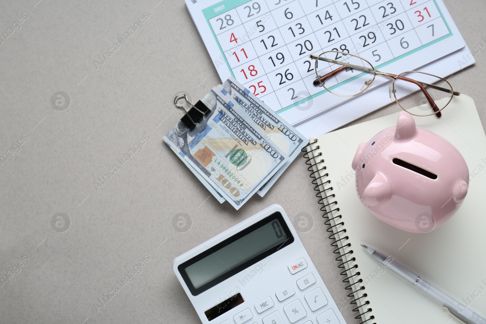 Photo of Flat lay composition with piggy bank and calculator on light grey background. Space for text