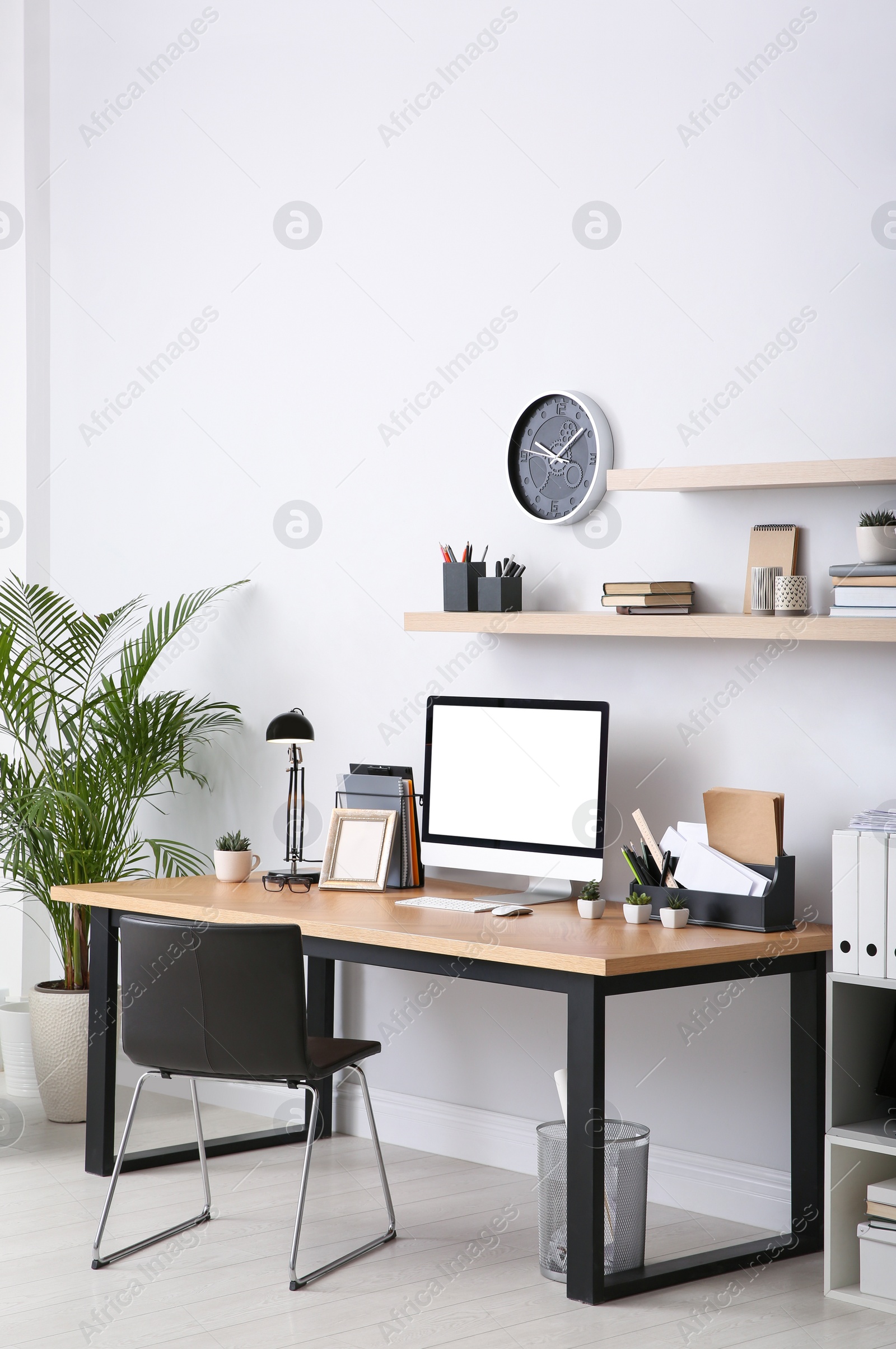 Photo of Modern computer on table in office interior. Stylish workplace