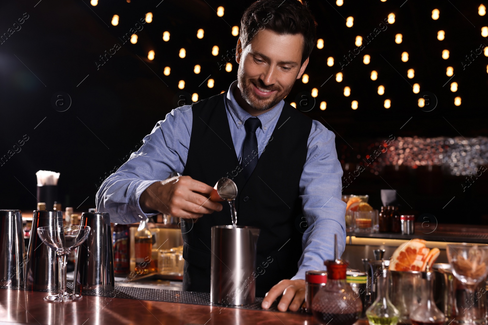 Photo of Bartender preparing fresh alcoholic cocktail in bar