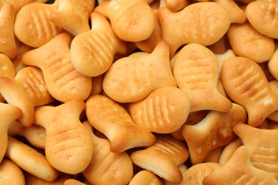 Delicious goldfish crackers as background, closeup view