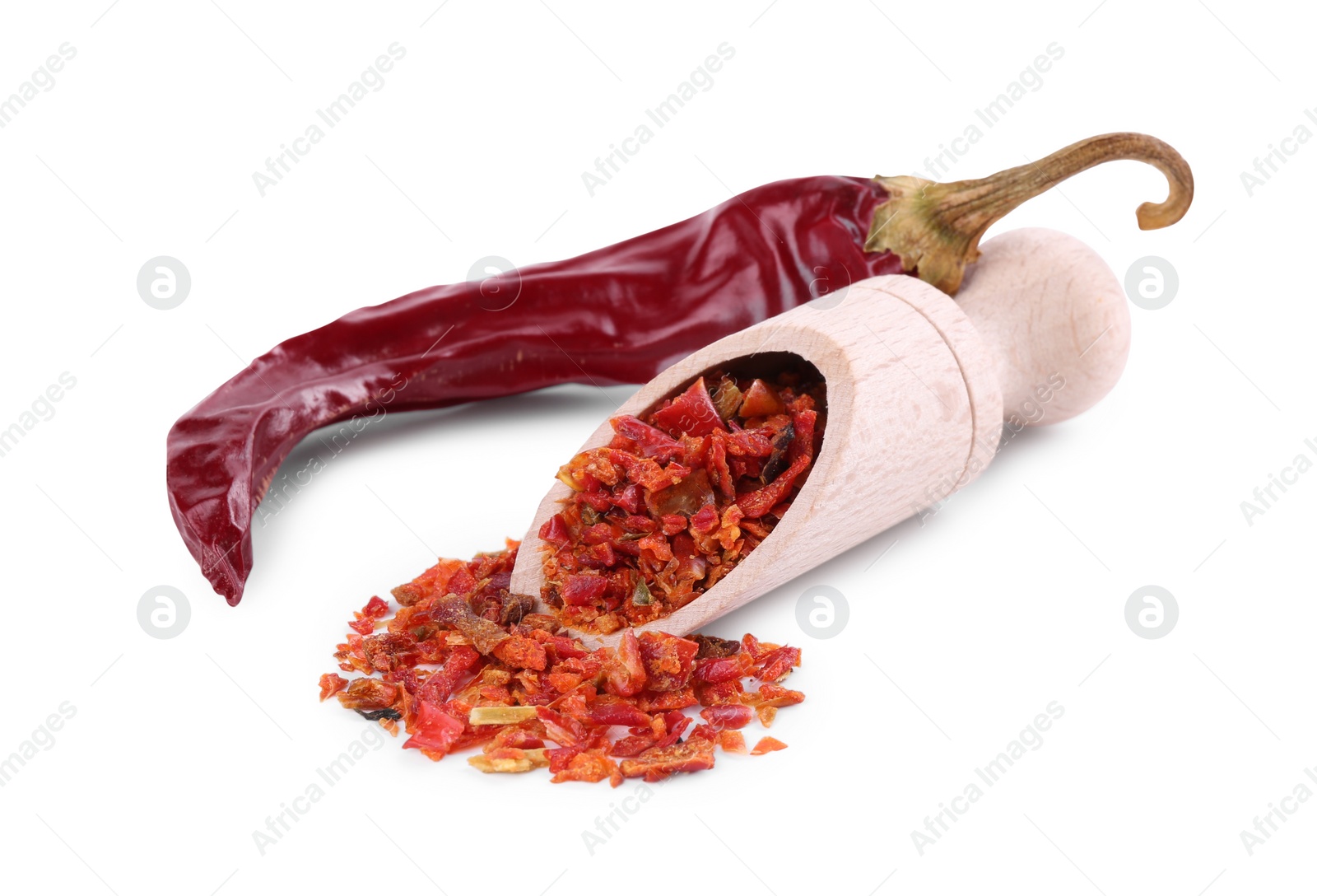 Photo of Aromatic spice. Red chili pepper flakes in scoop and pod isolated on white