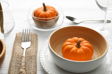 Photo of Autumn table setting with pumpkin on white wooden background, closeup