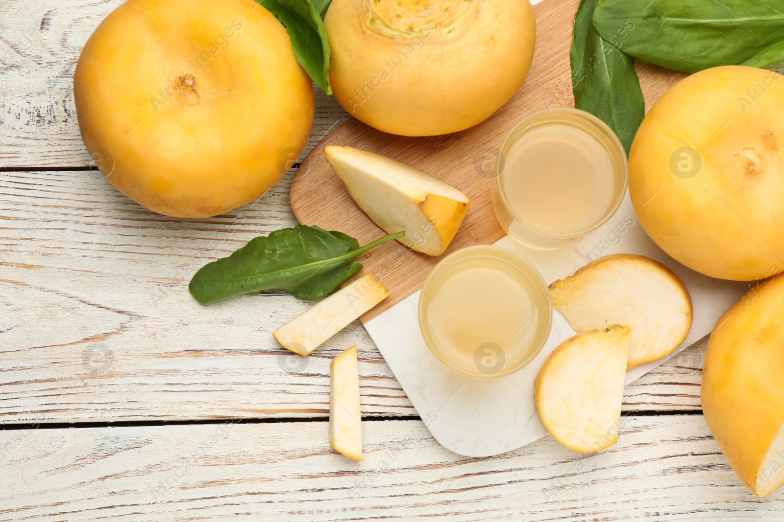 Photo of Freshly made turnip juice on white wooden table, flat lay