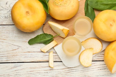 Photo of Freshly made turnip juice on white wooden table, flat lay