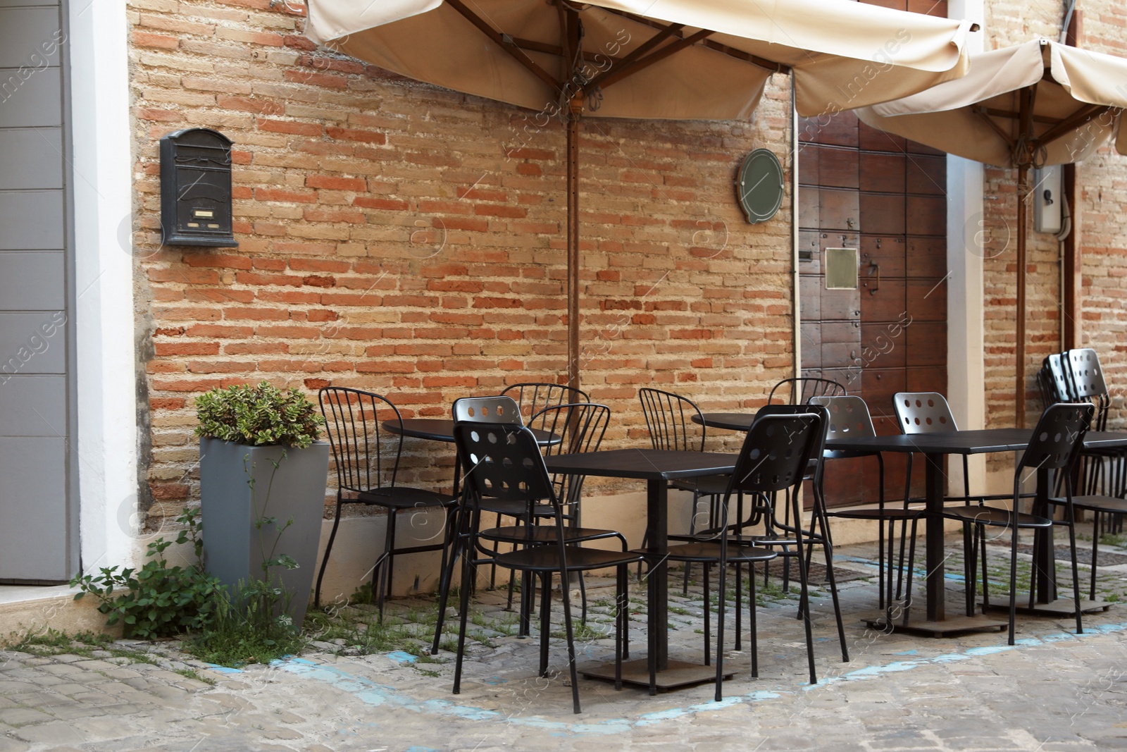 Photo of Tables and chairs near building. Outdoor cafe