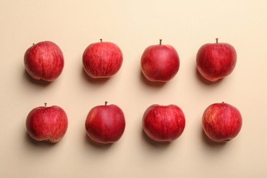 Fresh red apples on beige background, flat lay