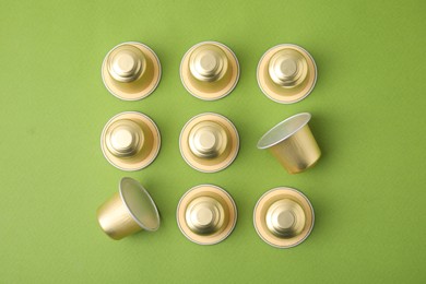 Photo of Many coffee capsules on green background, flat lay