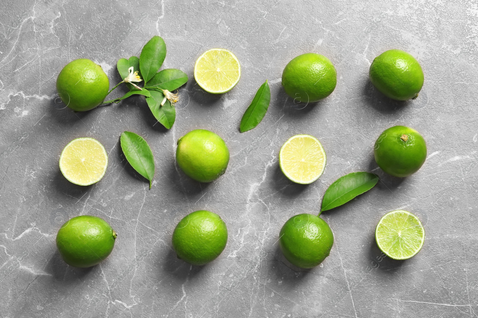 Photo of Flat lay composition with fresh ripe limes on gray background, top view