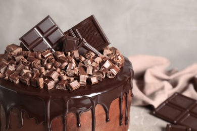 Photo of Freshly made delicious chocolate cake against grey background, closeup