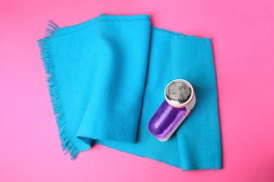 Light blue scarf and fabric shaver on pink background, top view