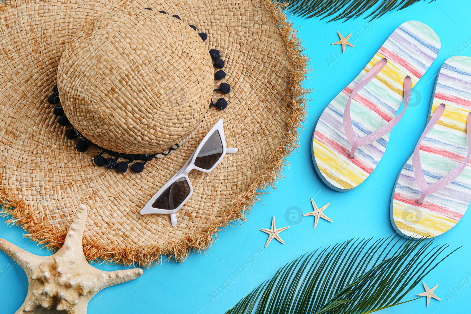 Photo of Flat lay composition with sunglasses and beach accessories on blue background