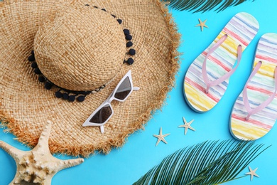 Flat lay composition with sunglasses and beach accessories on blue background