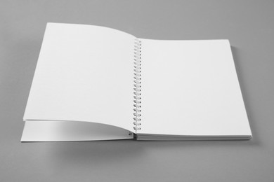 Photo of Open blank notebook on grey background. Mockup for design