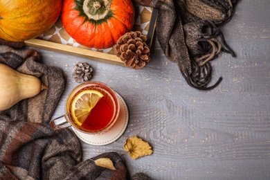 Photo of Flat lay composition with cup of hot drink on grey wooden table, space for text. Cozy autumn atmosphere