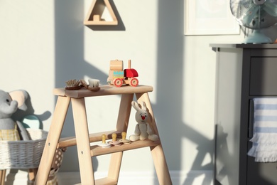 Photo of Stylish wooden ladder in baby room interior