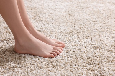 Woman on soft light brown carpet at home, closeup. Space for text