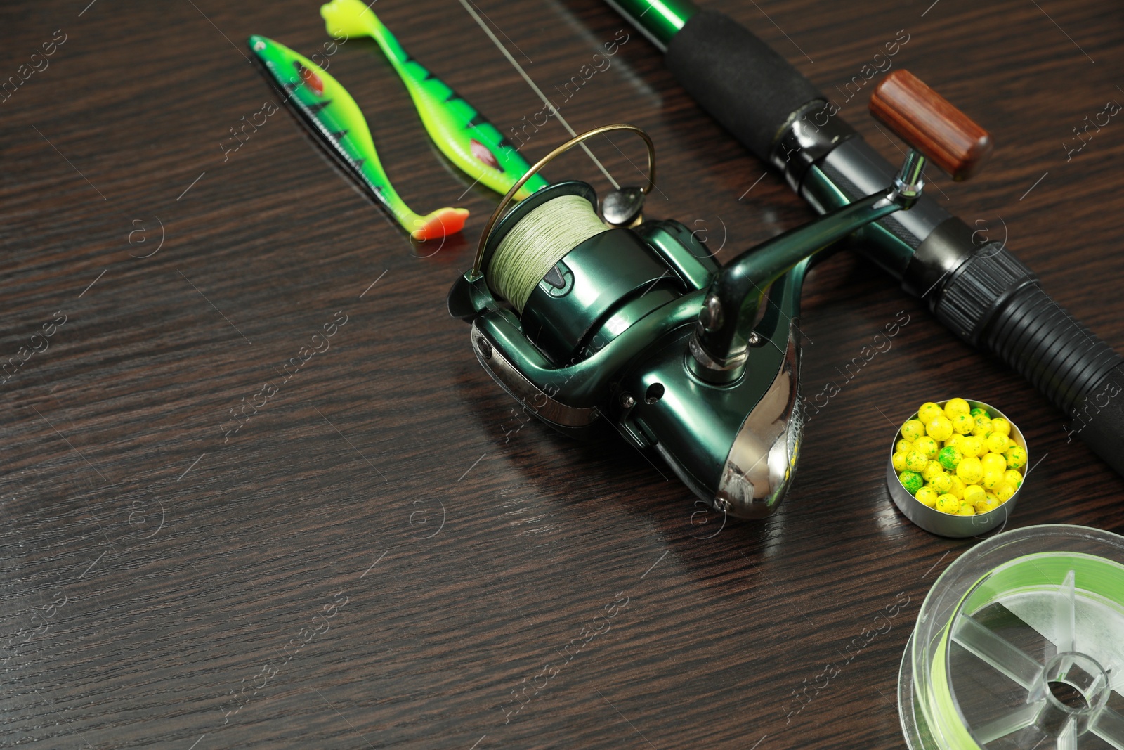 Photo of Fishing tackle on dark wooden background, closeup. Space for text