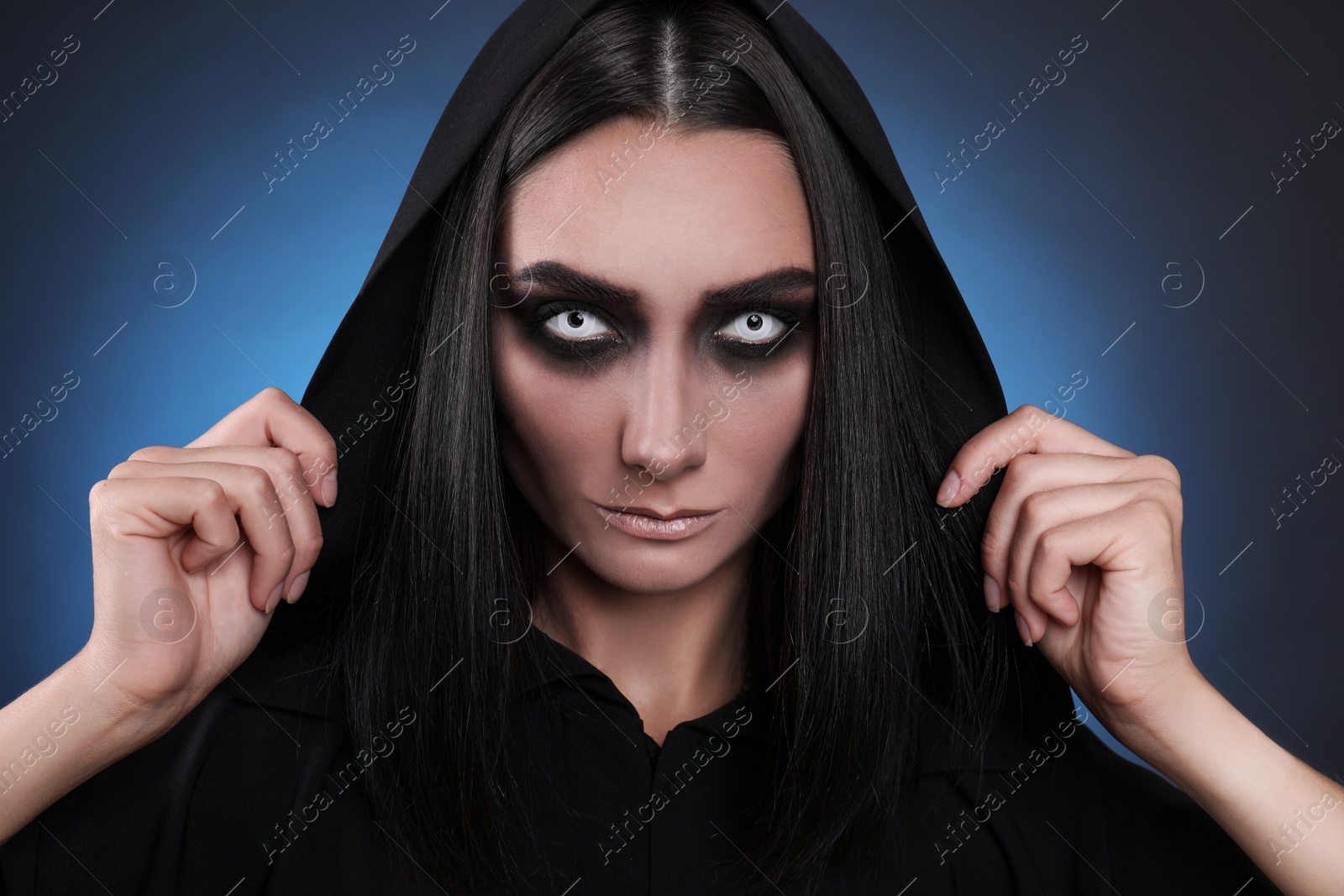 Photo of Mysterious witch with spooky eyes on color background, closeup