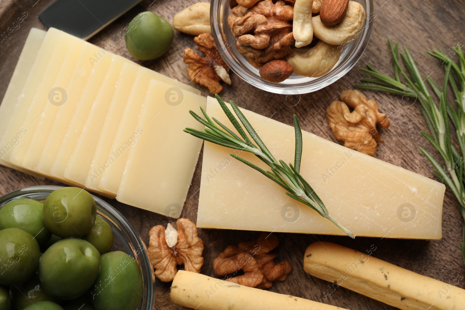 Photo of Snack set with delicious Parmesan cheese on wooden plate, closeup