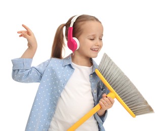 Photo of Cute little girl in headphones with broom singing on white background