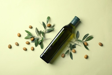 Photo of Flat lay composition with bottle of olive oil on color background