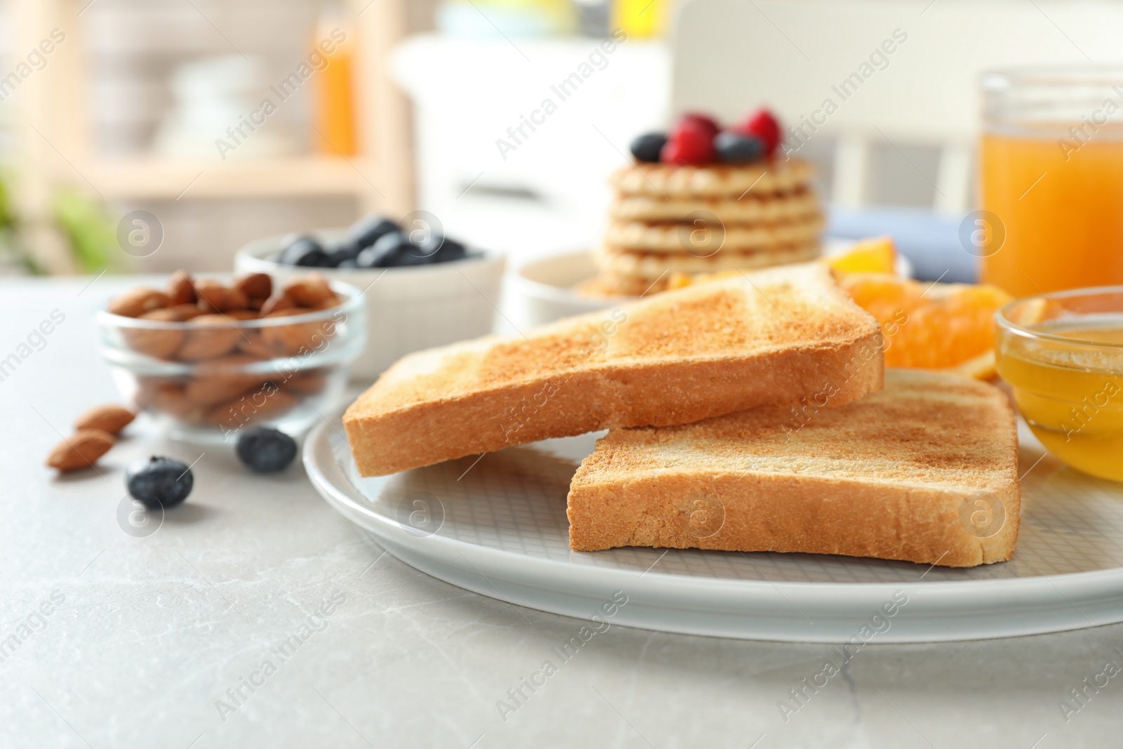 Photo of Delicious breakfast with toasted bread served on light table, closeup