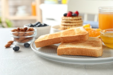 Photo of Delicious breakfast with toasted bread served on light table, closeup